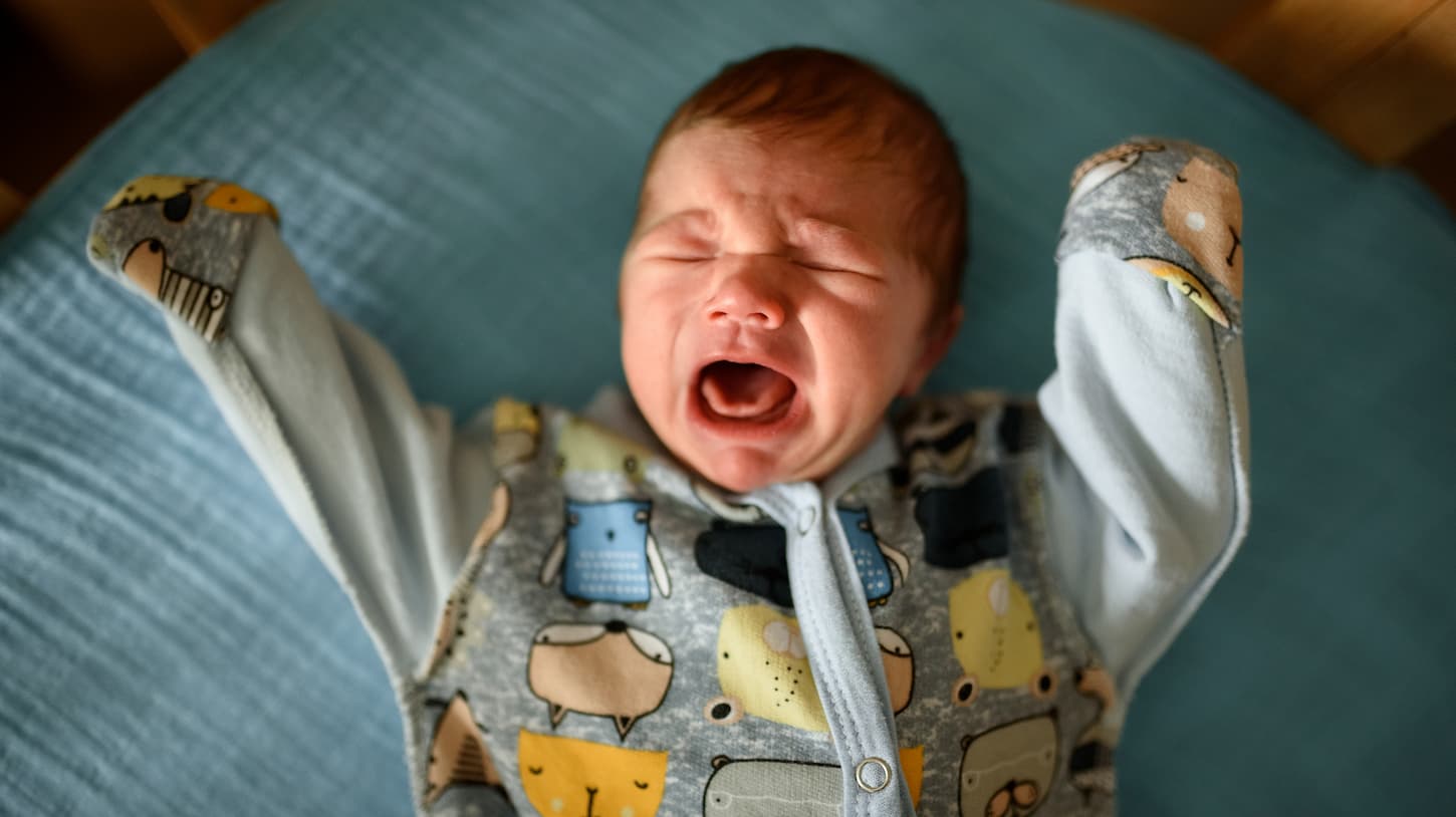 An image of Little newborn boy in his crib. 