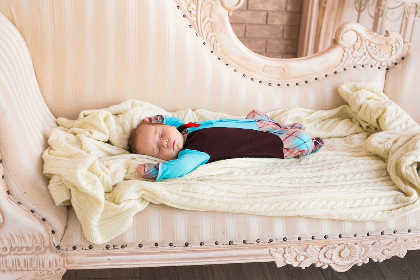 An image of a sleeping newborn baby on a blanket indoors.