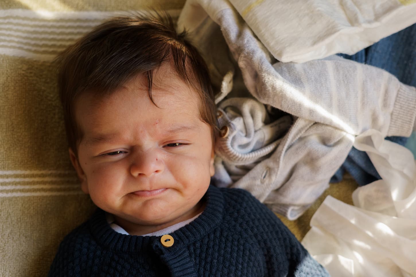 An image of a little one-month-old baby with an angry face.