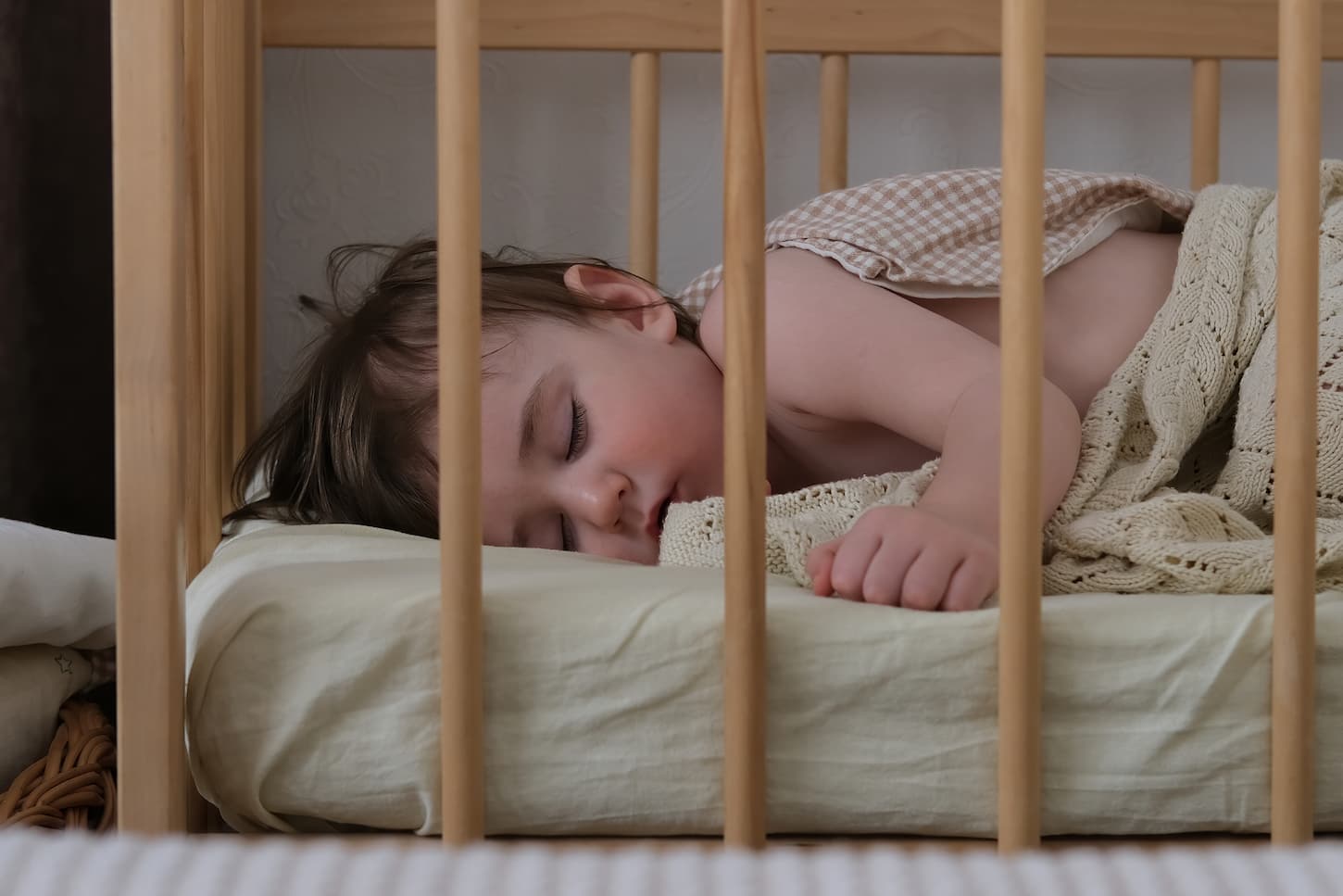 An image of a baby boy sleeping sweetly in a crib.