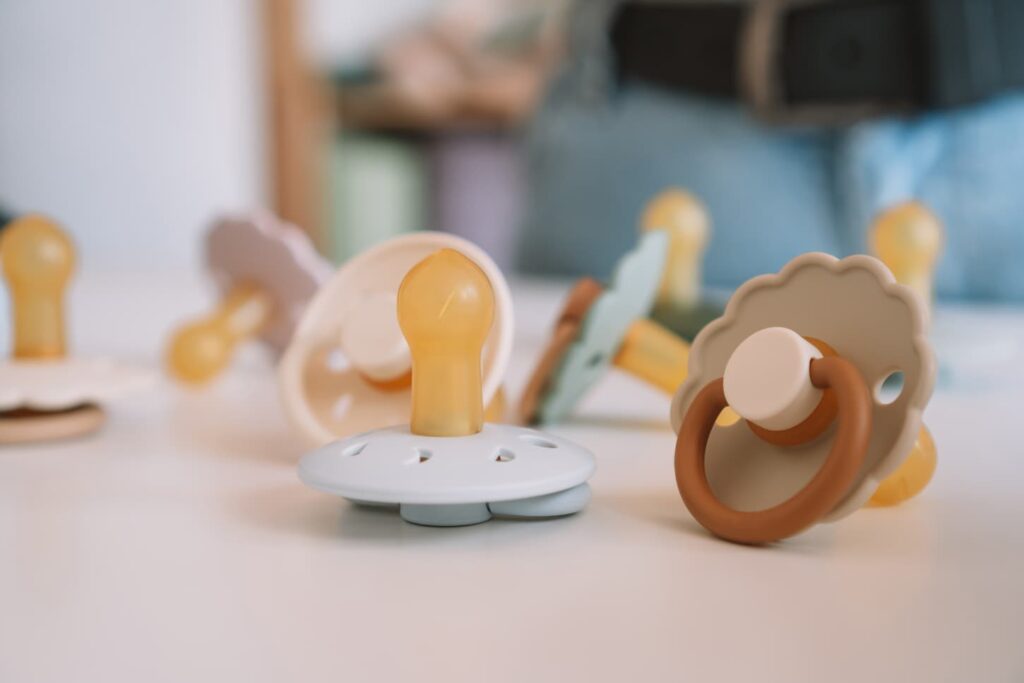 An image of pacifiers in a wooden table as baby accessories for babies.