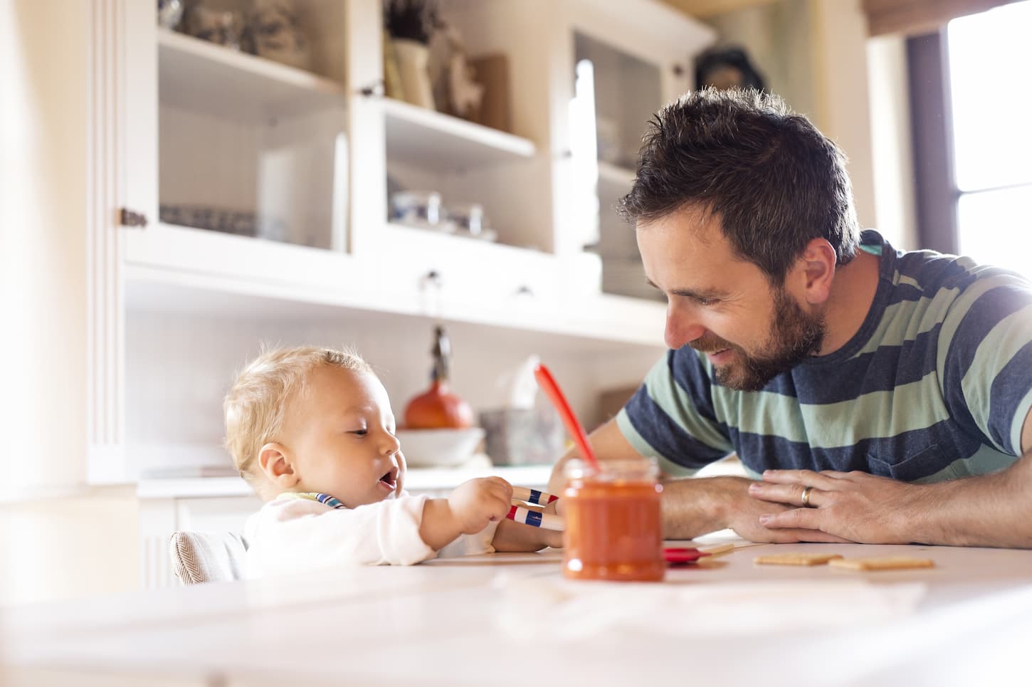 An image of a Father and baby at home at the dining table.